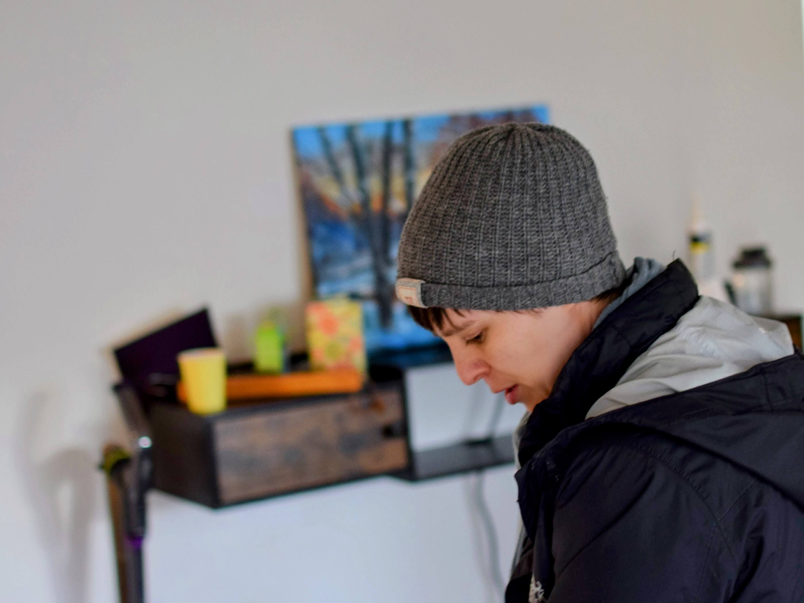 Amber in profile, looking at something on the ground, standing in an out of focus background of a painting and mess IN OUR FREAKING HOUSE!!!