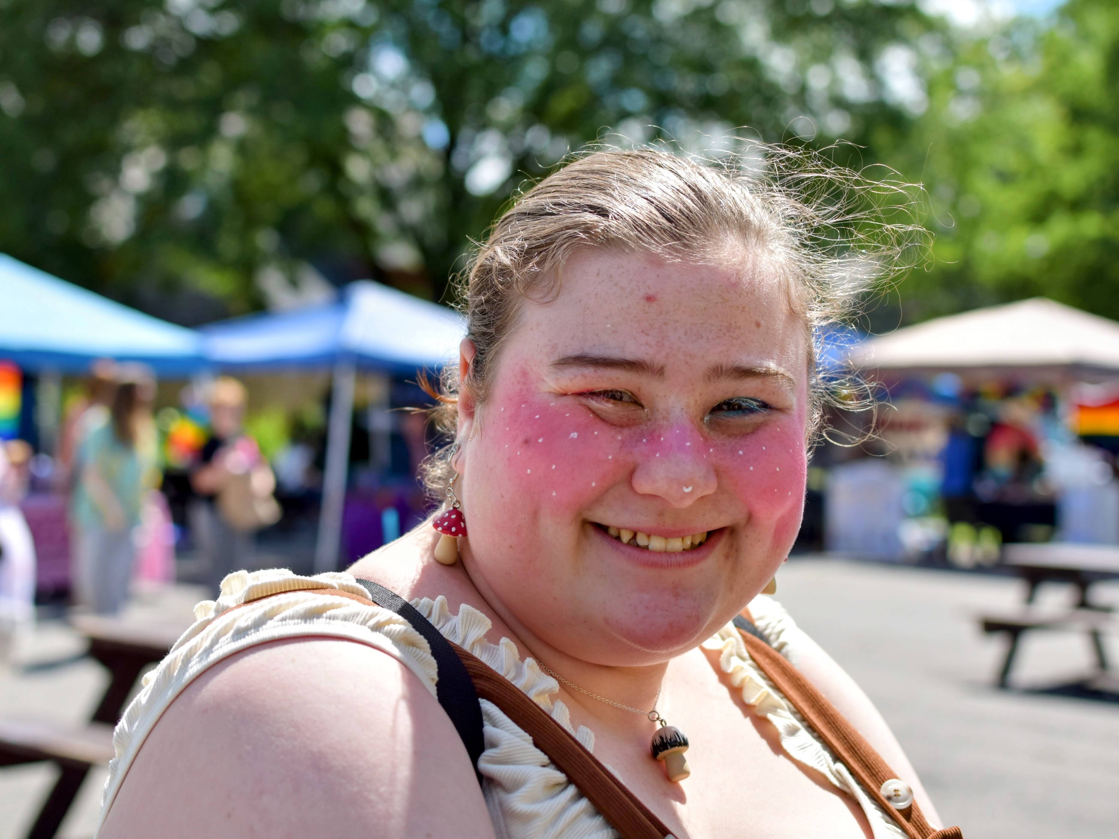 A grinning woman with pink makeup