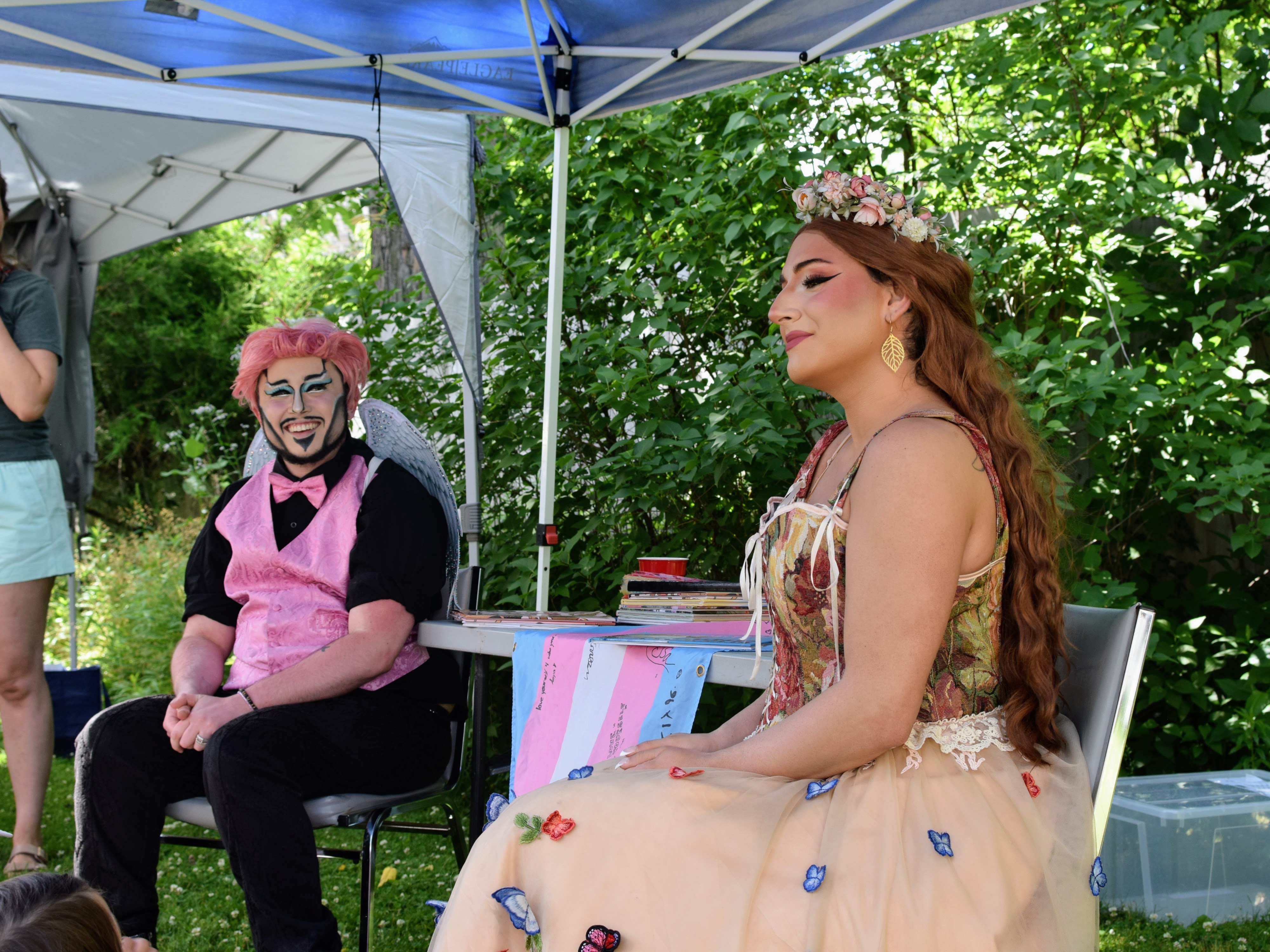 A person in a pink vest and a woman in a soft pink dress