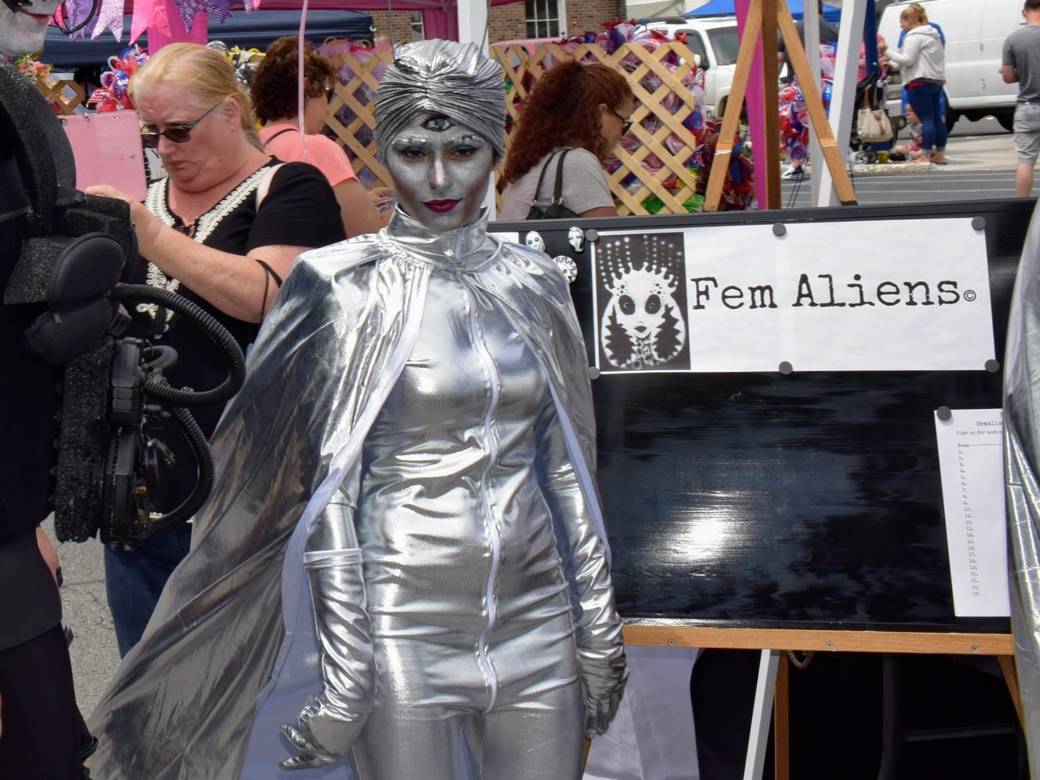 A woman in silver face paint and a silver body suit