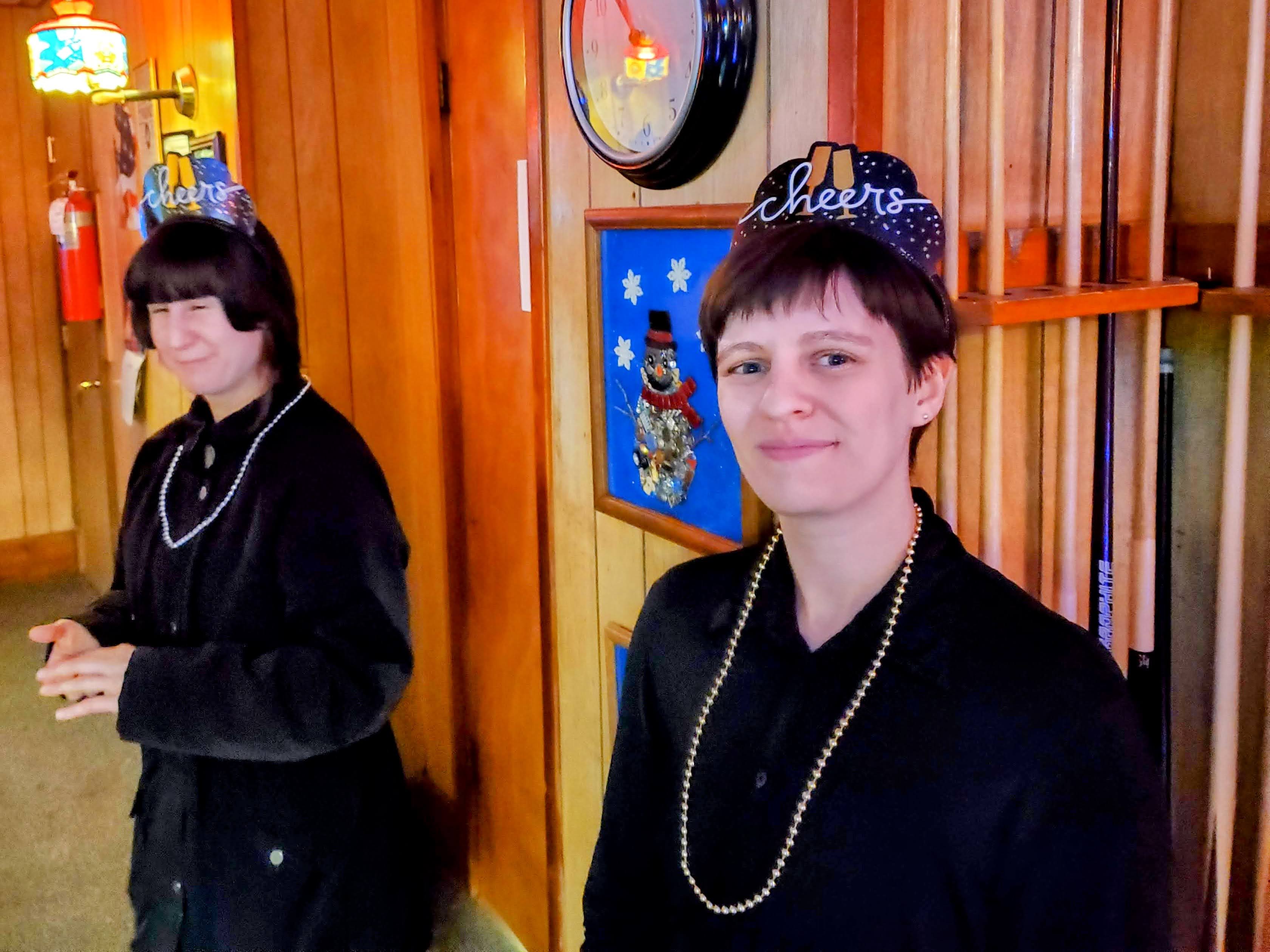 Kristina and Amber in New Year's Eve tiaras, standing in front of a billiard rack